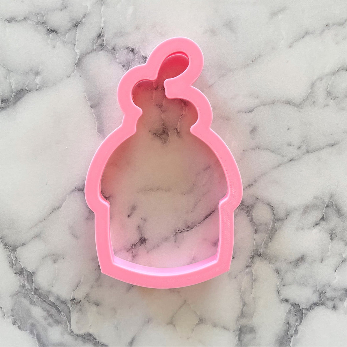 Pink plastic bunny muffin cookie cutter shaped like a cupcake with a bunny face for baking and decorating