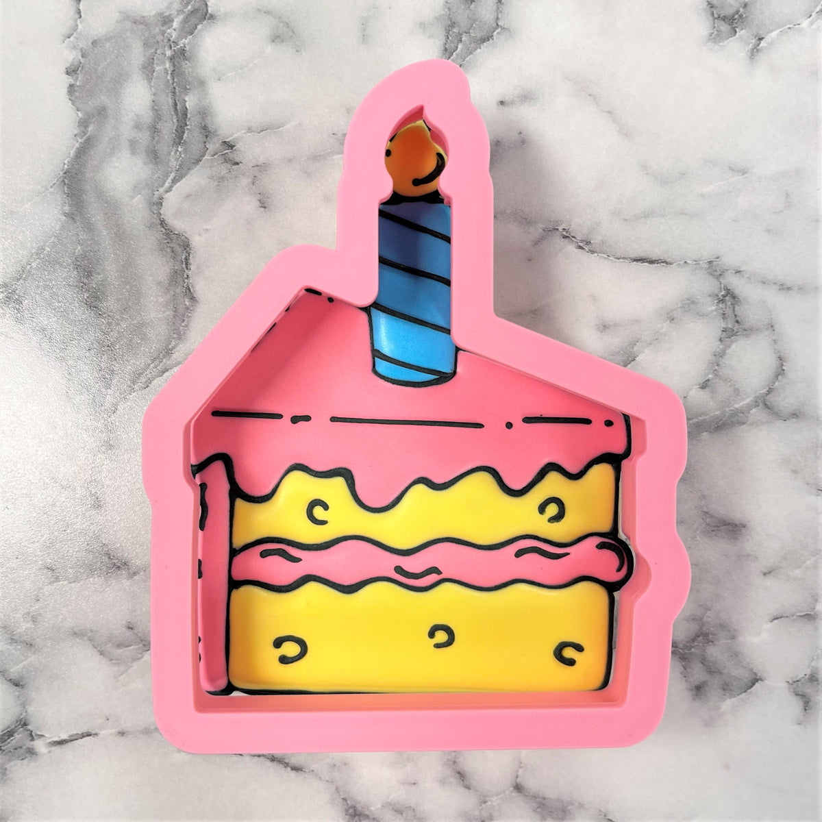 Pink silicone cake slice with candle cookie cutter featuring a blue striped candle and yellow layers design