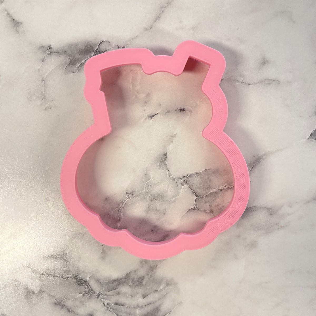 Pink silicone bunny mold holding a white marbled soap bar for candy jack-o-lantern flour box club cookie cutter