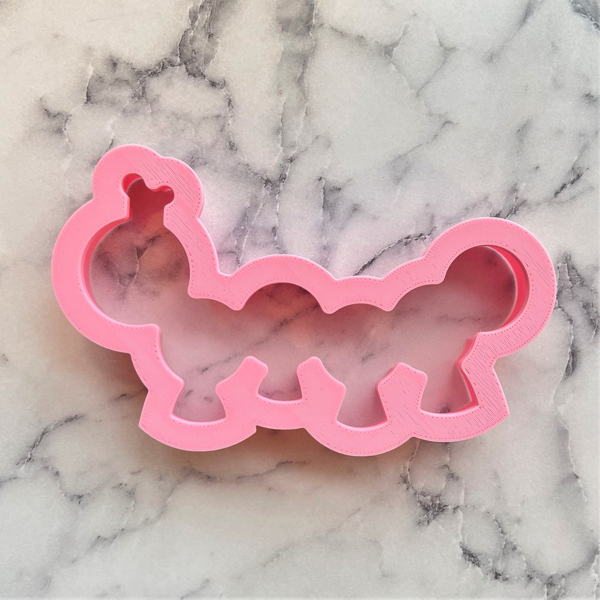 Pink plastic caterpillar-shaped cookie cutter designed for fun and creative baking projects