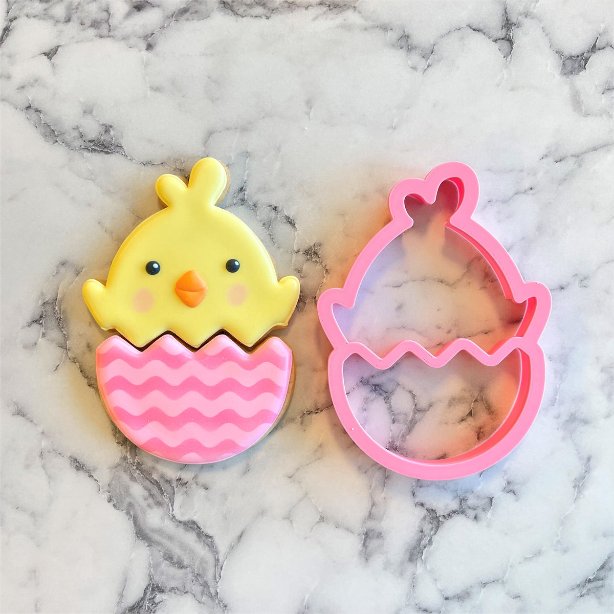 Yellow chick cookie with pink wavy-striped eggshell base and matching pink plastic easter egg cutter chick in egg 2-in-1 multi-cookie cutter