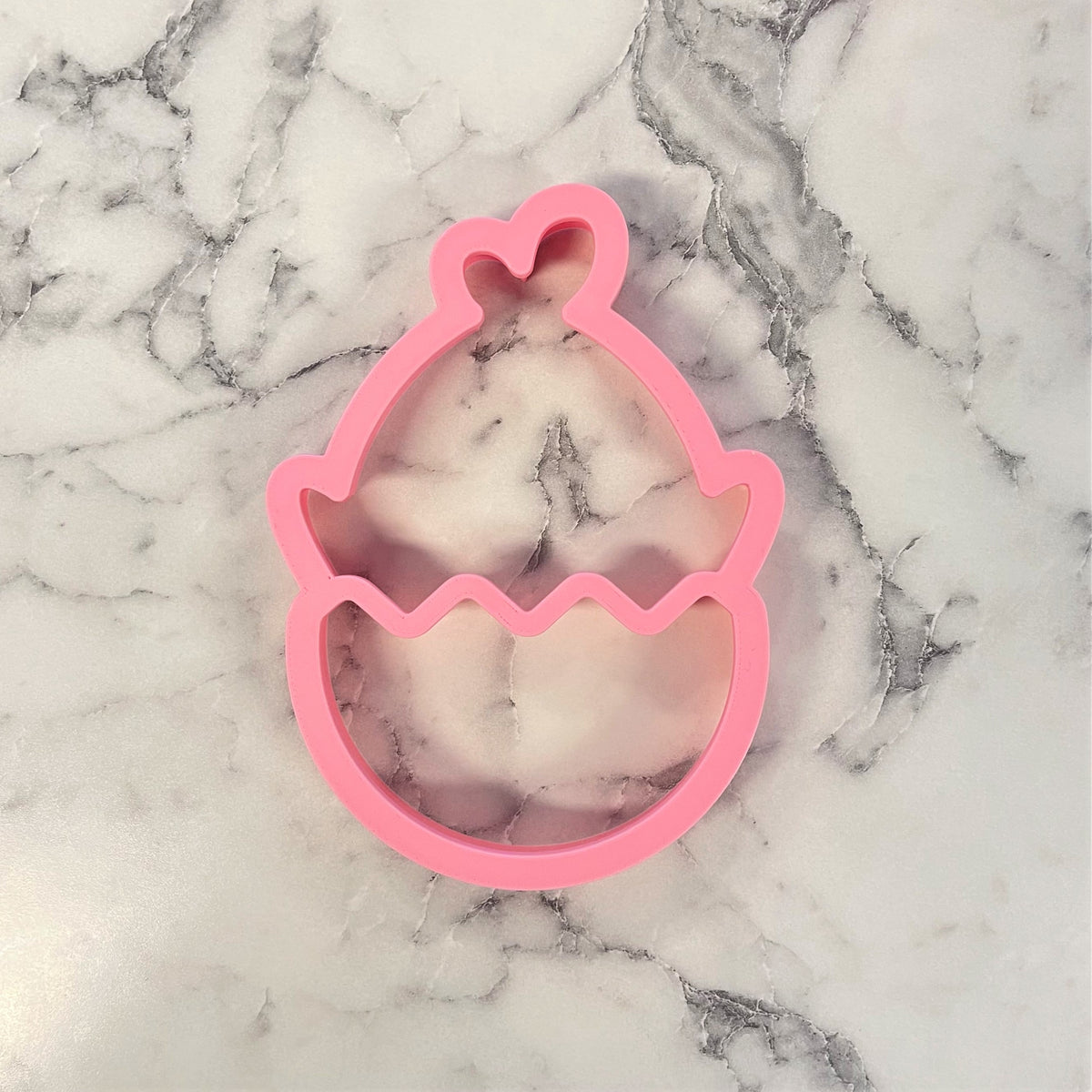 Pink silicone chick in egg 2-in-1 multi-cookie cutter with wavy bottom edge and heart detail on top