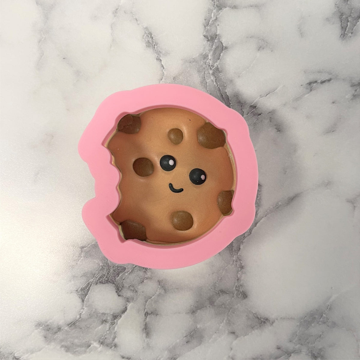 Mini chocolate chip cookie cutter pink silicone mold with smiling chocolate chip cookie design interior