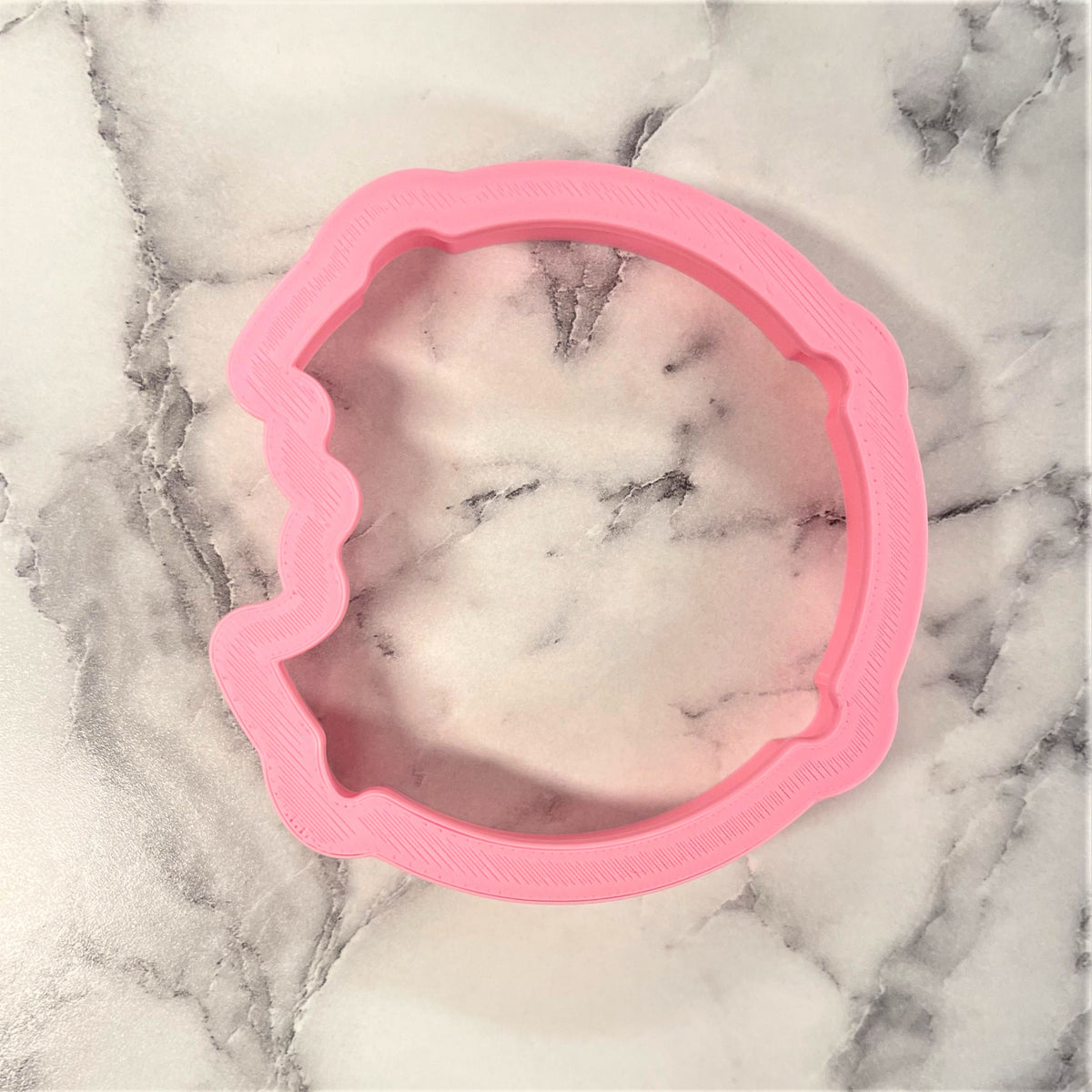 Pink silicone chocolate chip cookie cutter shaped like a unicorn head for baking and crafting