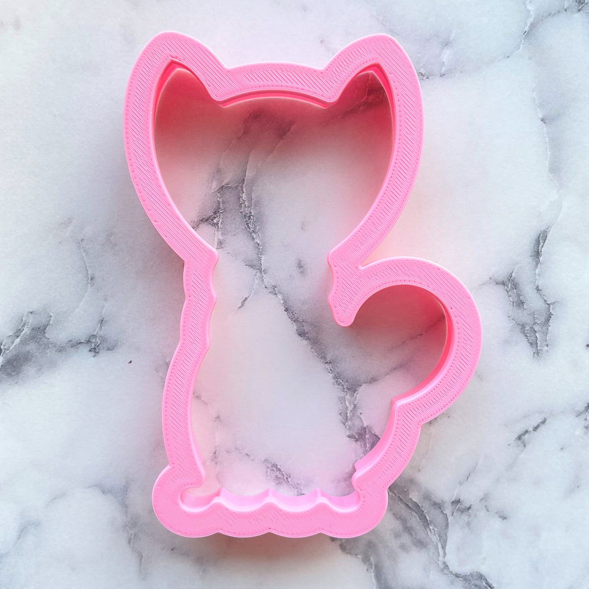 Pink plastic cat shaped cookie cutter for classic black cat cookie baking and crafting