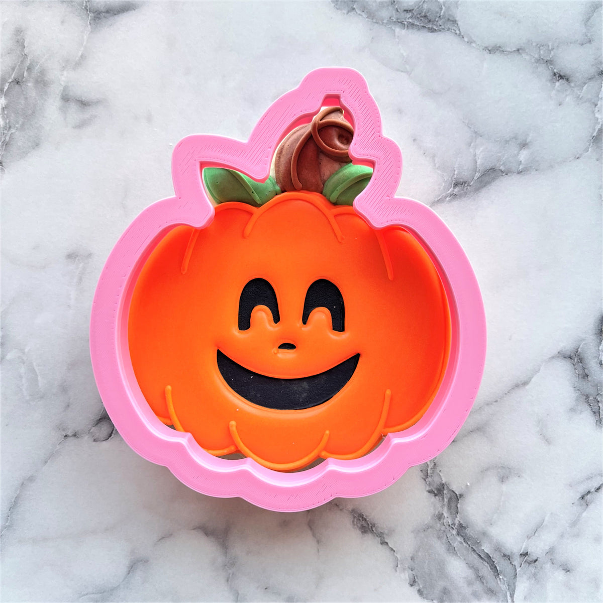Classic pumpkin cookie cutter pink plastic with smiling face green stem and brown rose detail for festive baking