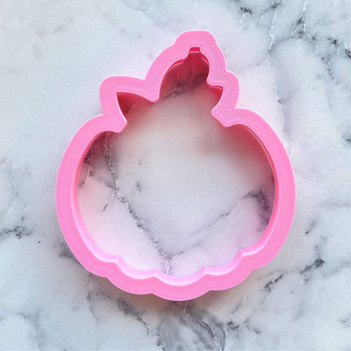 Pink plastic unicorn-shaped cookie cutter shown in front for classic pumpkin cookie cutter use