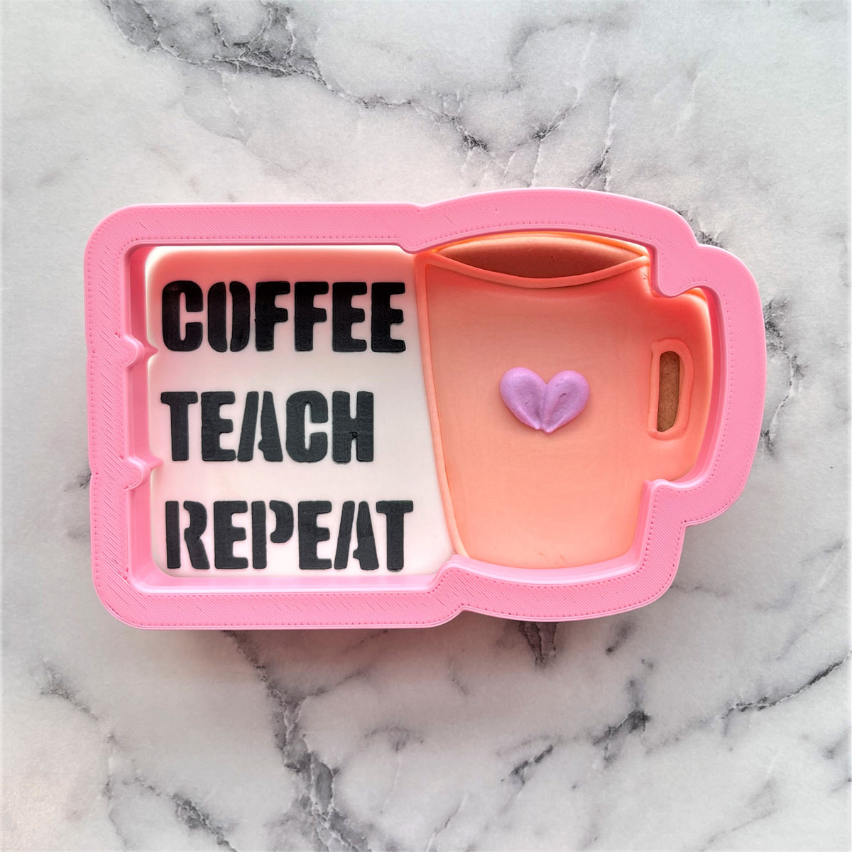 Pink coffee mug shaped cookie cutter with stencil featuring coffee teach repeat text and purple heart interior