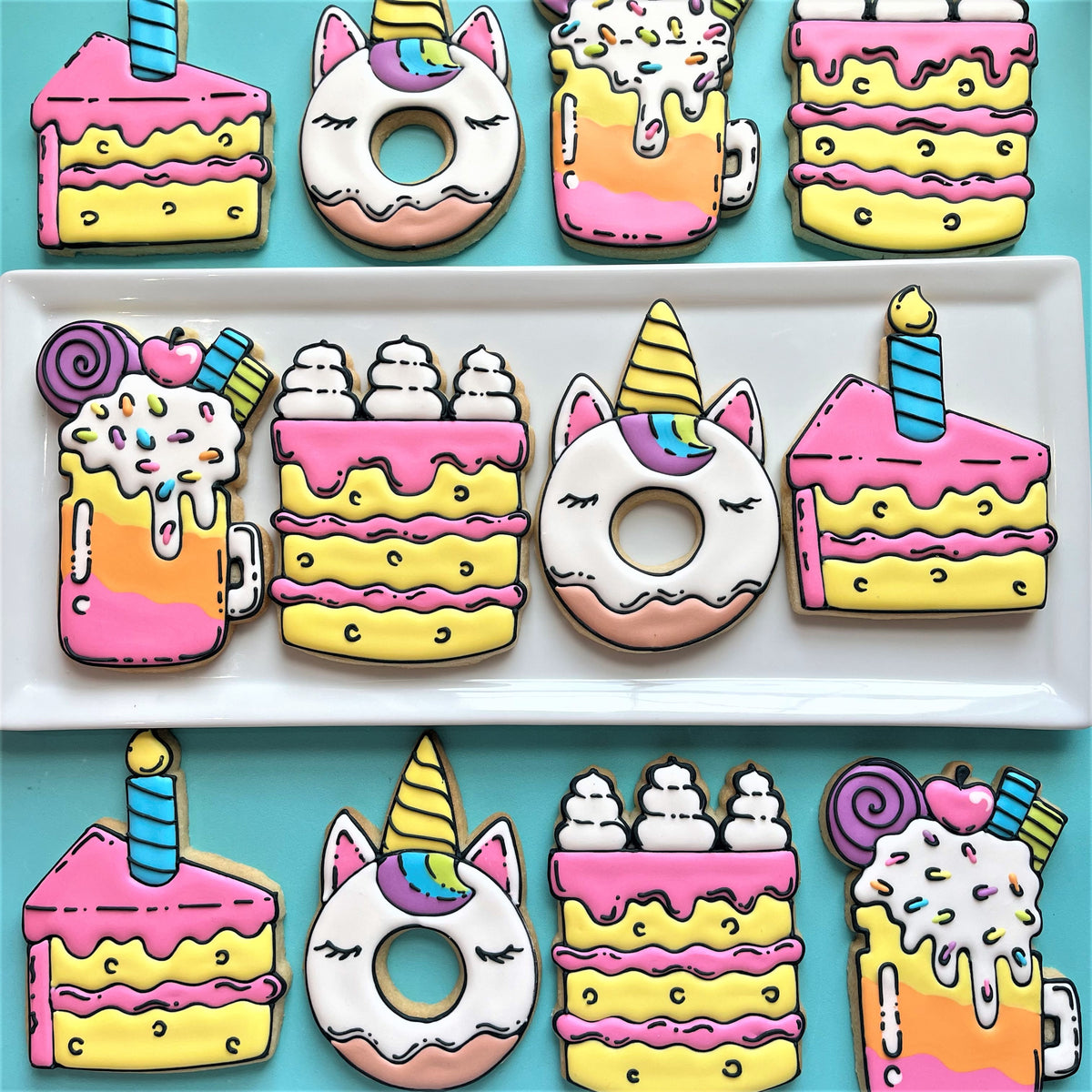 Pastel-colored unicorn-themed sugar cookies shaped like cakes donuts and drinks with rainbow icing using cake slice with candle cookie cutter
