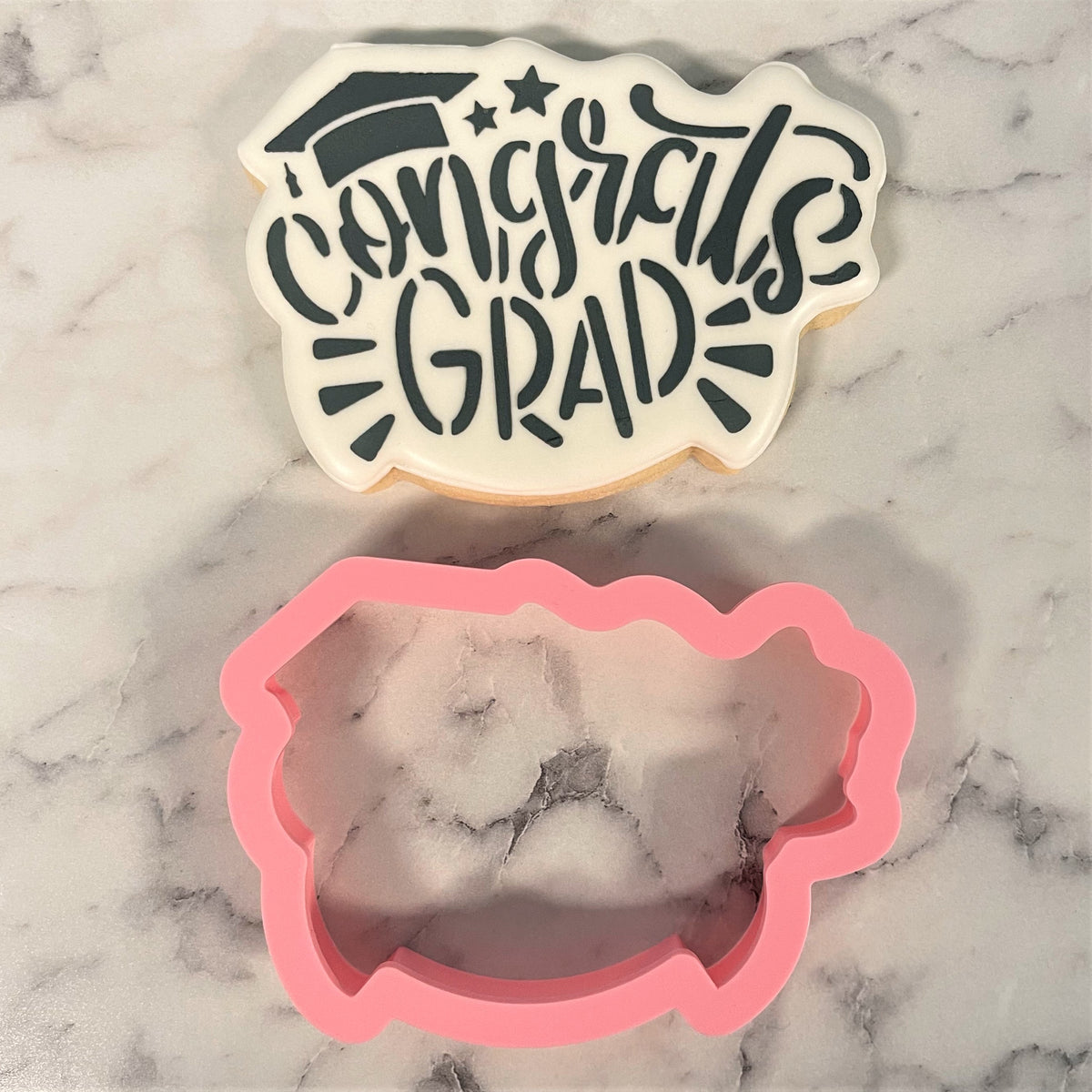 Pink silicone graduation cap cookie cutter with congrats grad stencil for making decorated cookies