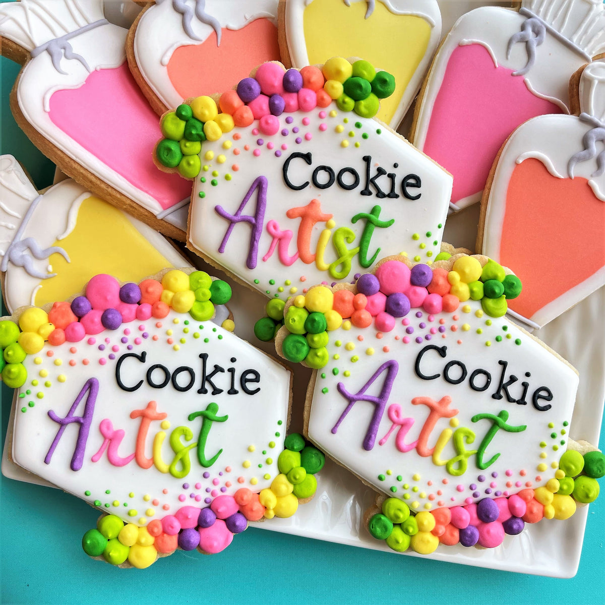 Colorful rainbow-dotted hexagonal cookies decorated with vibrant icing made using floral plaque cookie cutter