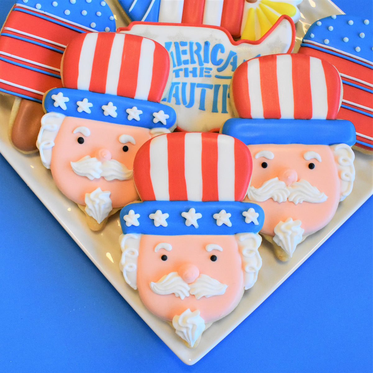 Uncle sam gnome cookie cutter used to create red white and blue frosted sugar cookies with detailed icing faces