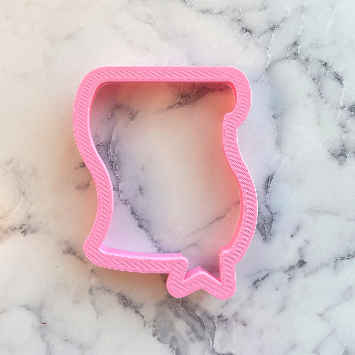 Pink plastic cookie cutter shaped like a speech bubble for diploma with seal themed cookies