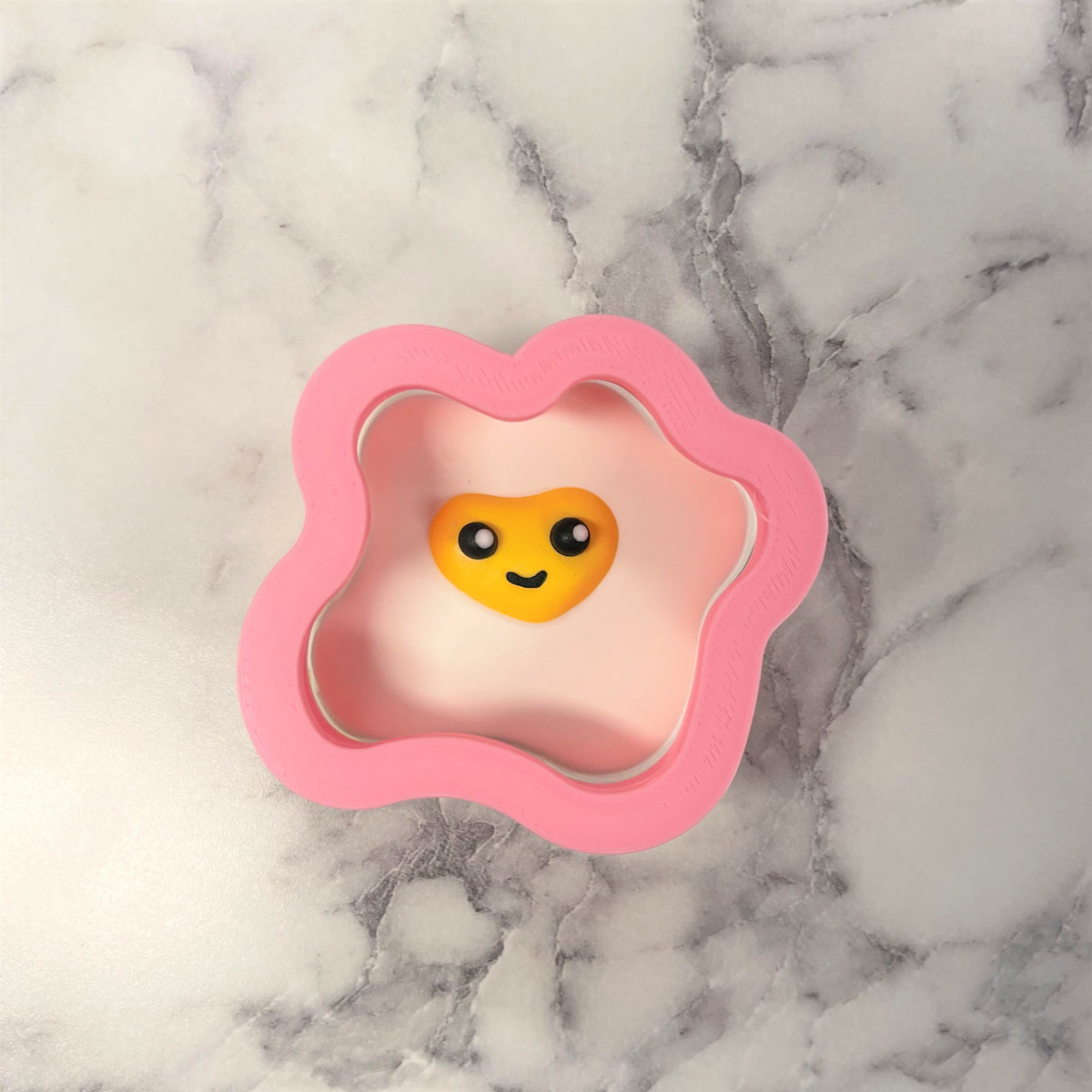 Pink silicone mini fried egg cookie cutter with yellow smiling face perfect for baking and crafts
