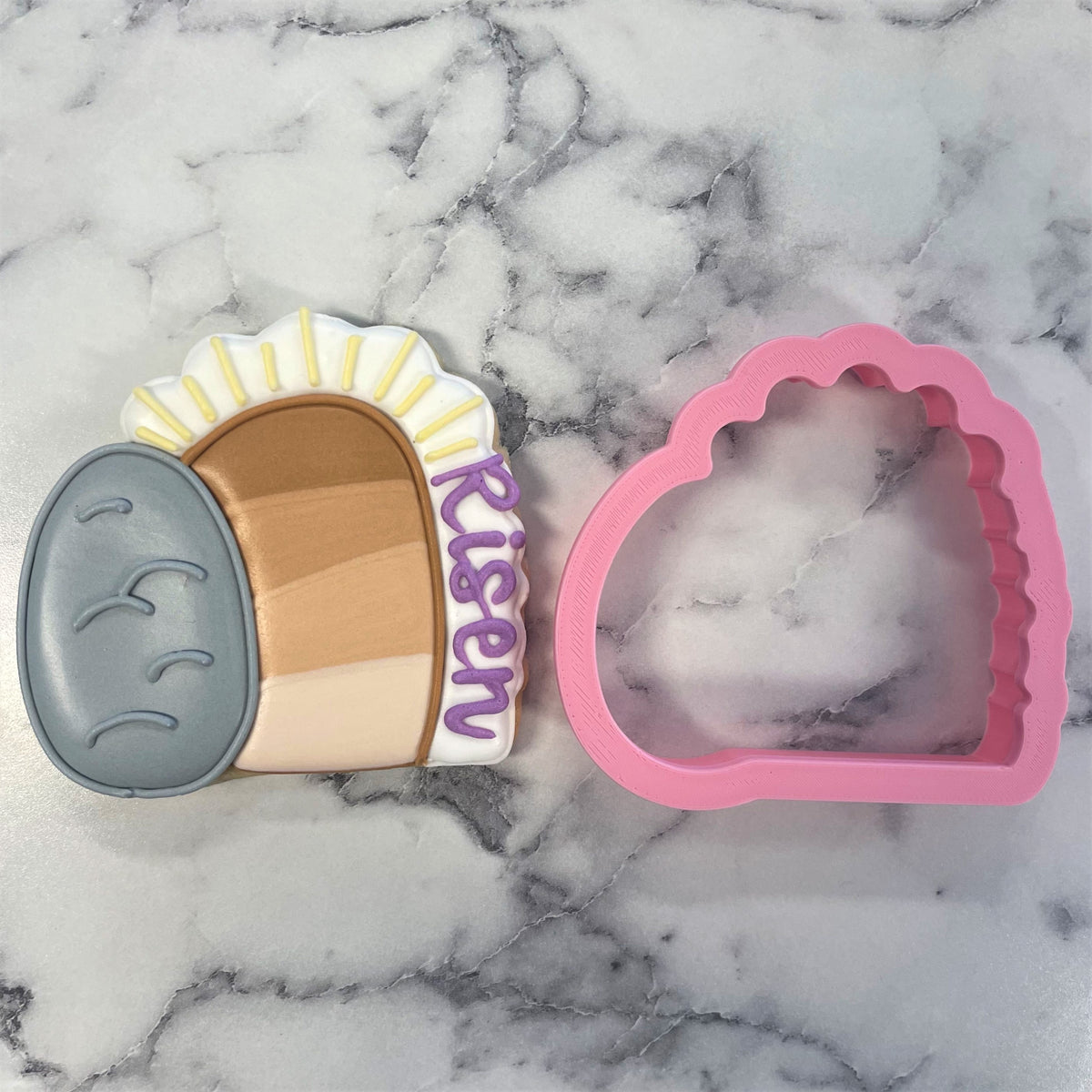 Pink silicone empty tomb cookie cutter shaped like a cloud for baking and decorating Easter cookies