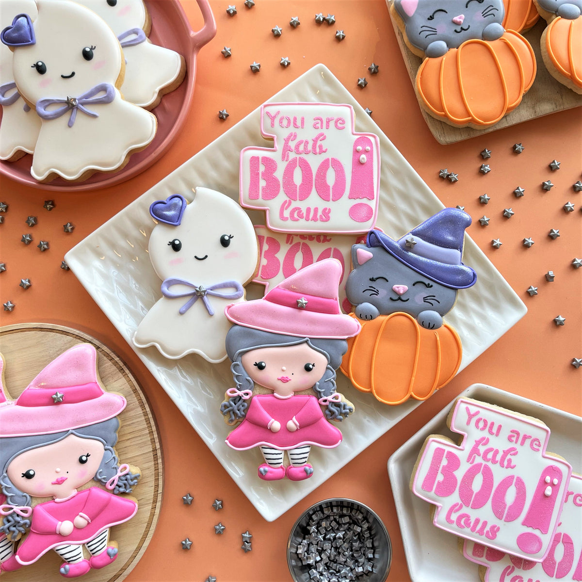 Fab-boo-lous witch cookie cutter with a pink witch cookie featuring gray hair striped skirt and purple hat