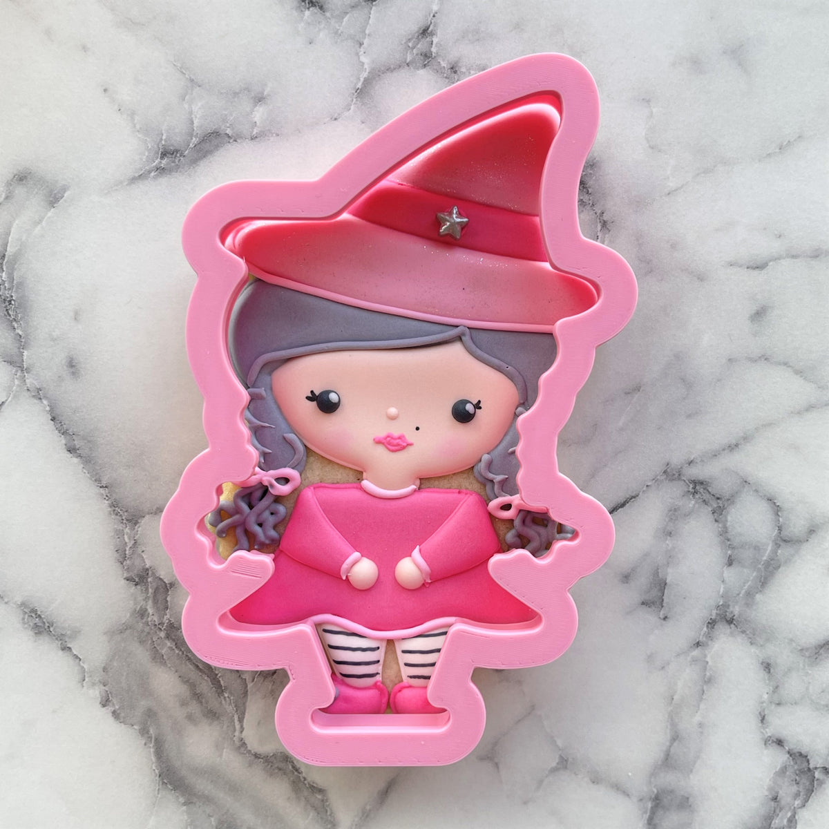 Fab-boo-lous witch cookie cutter in pink with a red hat silver star gray braided hair and striped leggings for baking