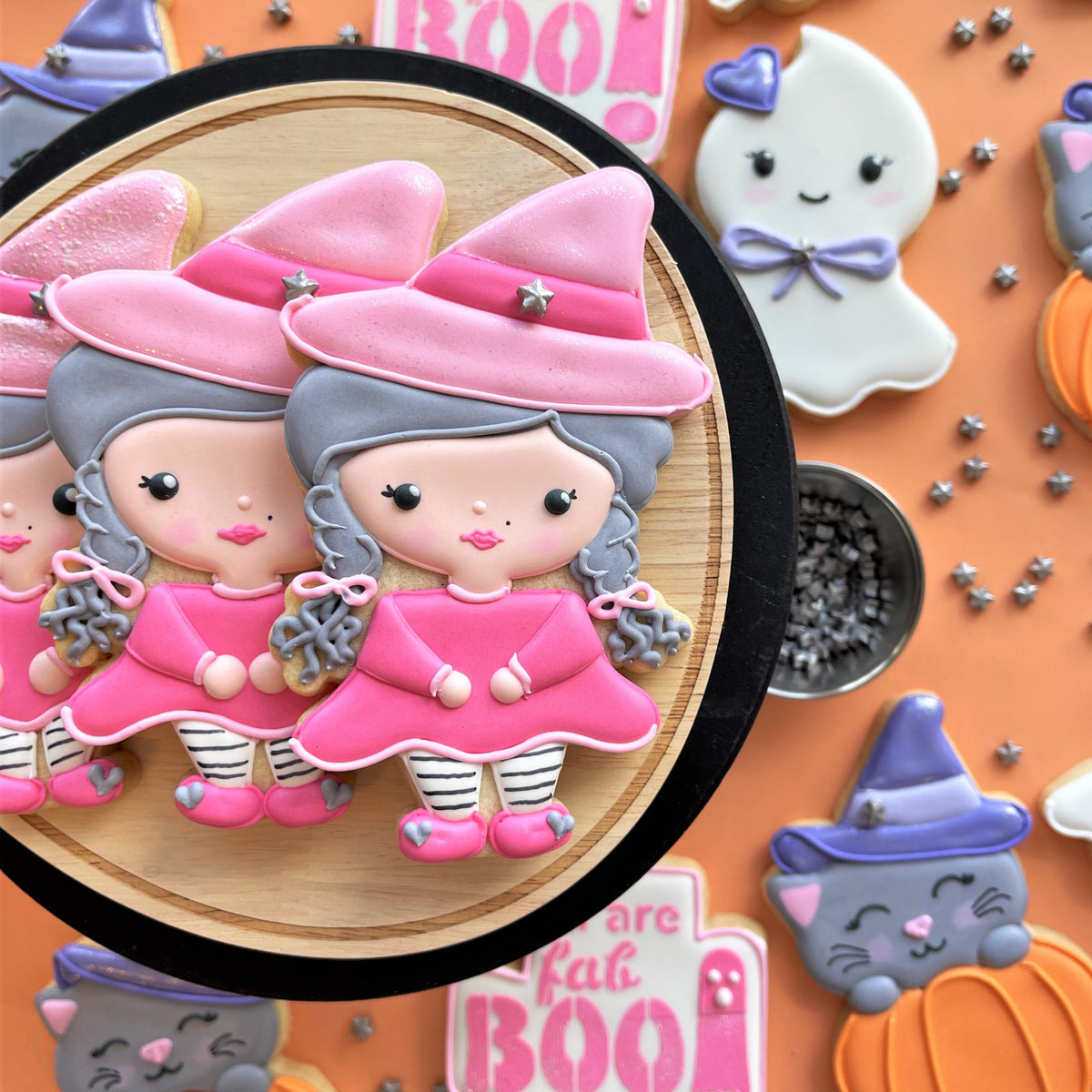 Fab-boo-lous witch cookie cutter pink sugar cookies with gray hair striped leggings and star adorned hats