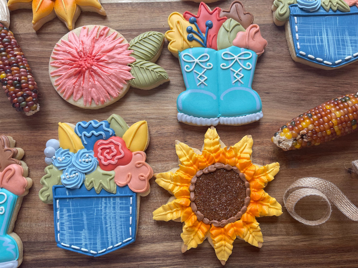 A vibrant yellow mum cookie decorated with glittery brown center and piped petals using mum cookie cutter