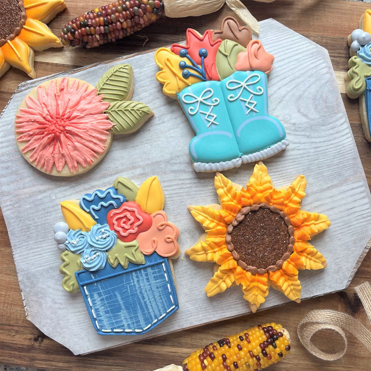 Vibrant autumn-themed sugar cookies shaped like sunflowers boots and floral arrangements made with flower boots cookie cutter