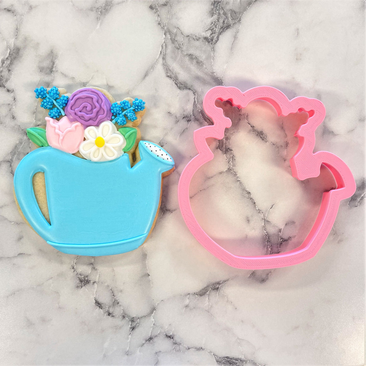 A pink plastic Floral Watering Can Flour Box Club cookie cutter with decorative handles and spout details