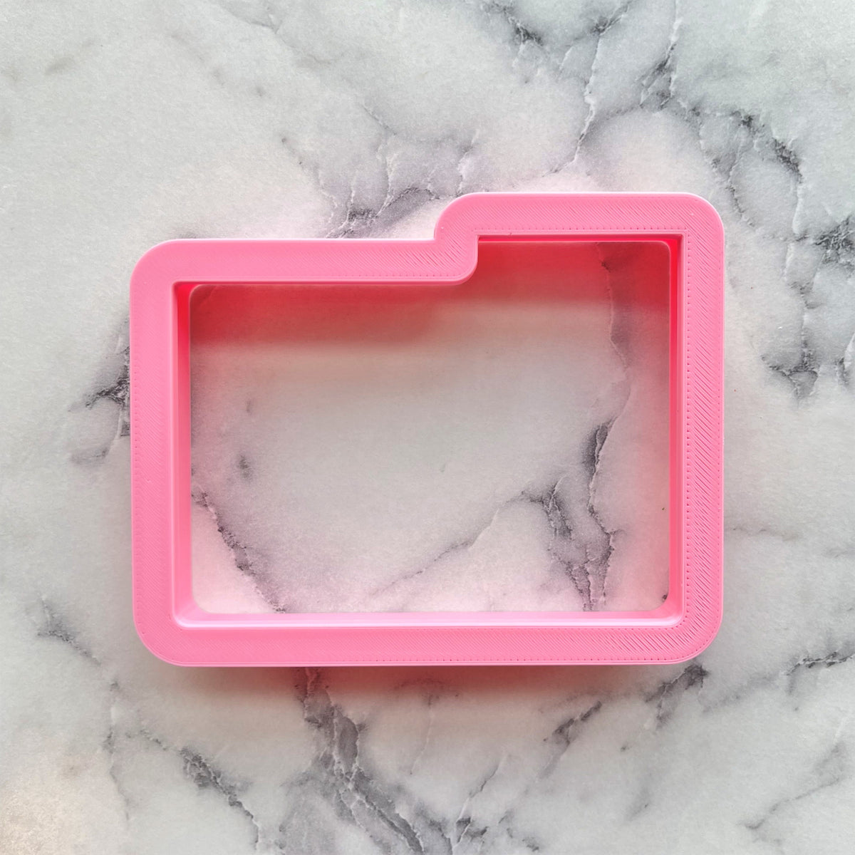 Pink silicone folder cookie cutter mold with marbled interior for baking and crafts
