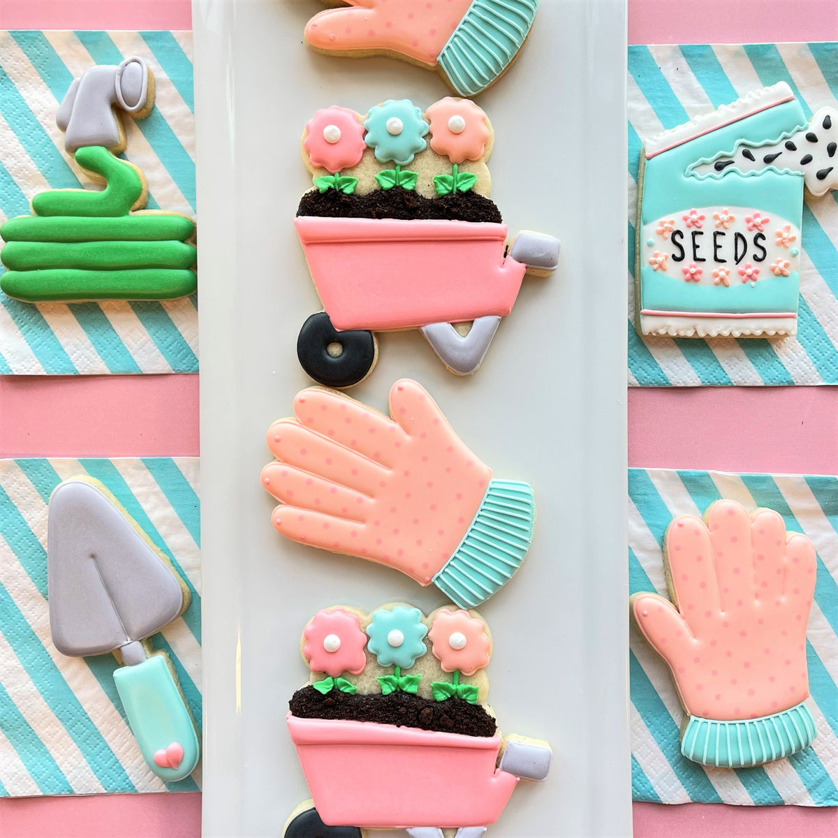 Pink sugar cookie shaped like a garden glove filled with chocolate soil and colorful flower cookies using cutter