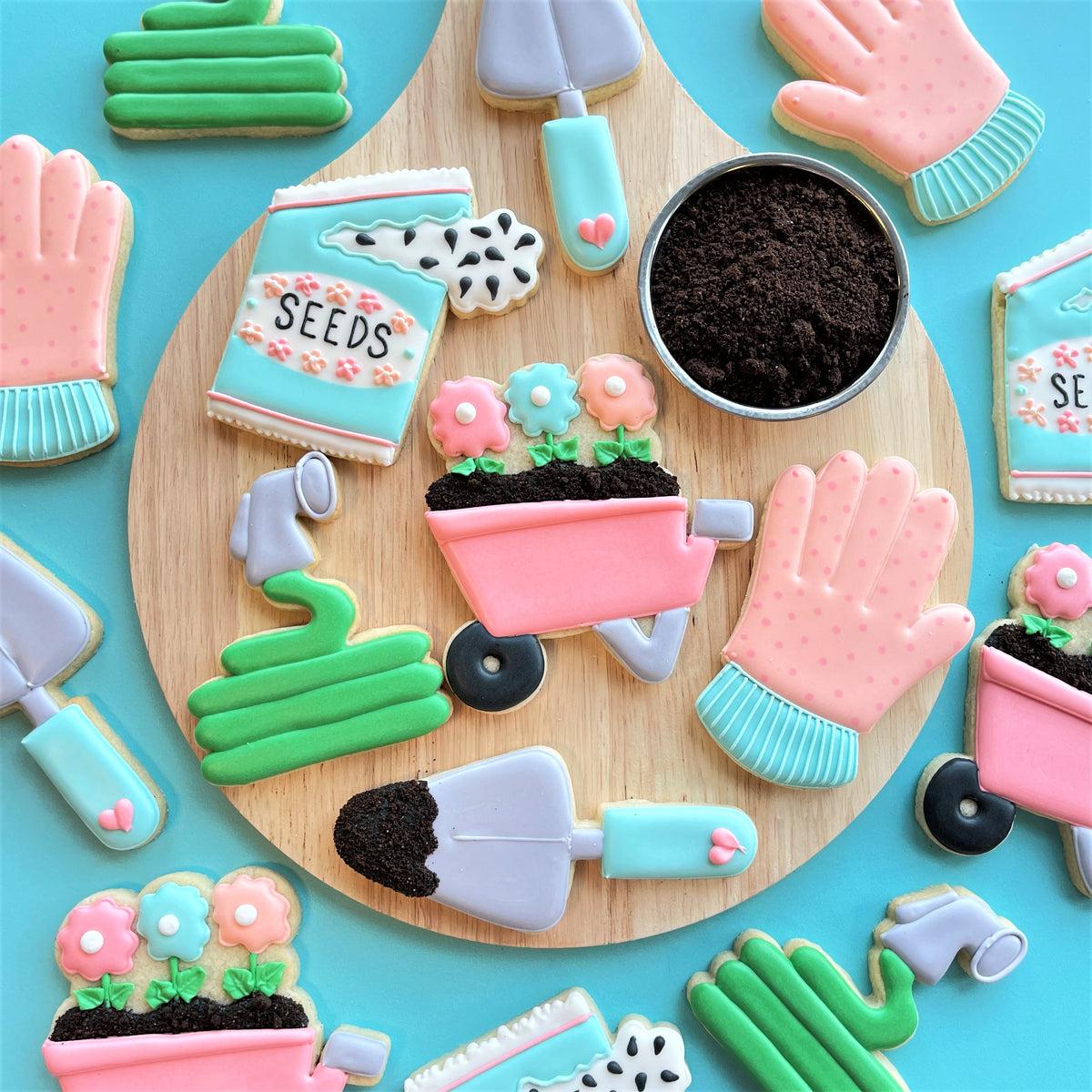 Pink flower pot cookie with black dirt and green stems made using garden hose cookie cutter for gardening treats