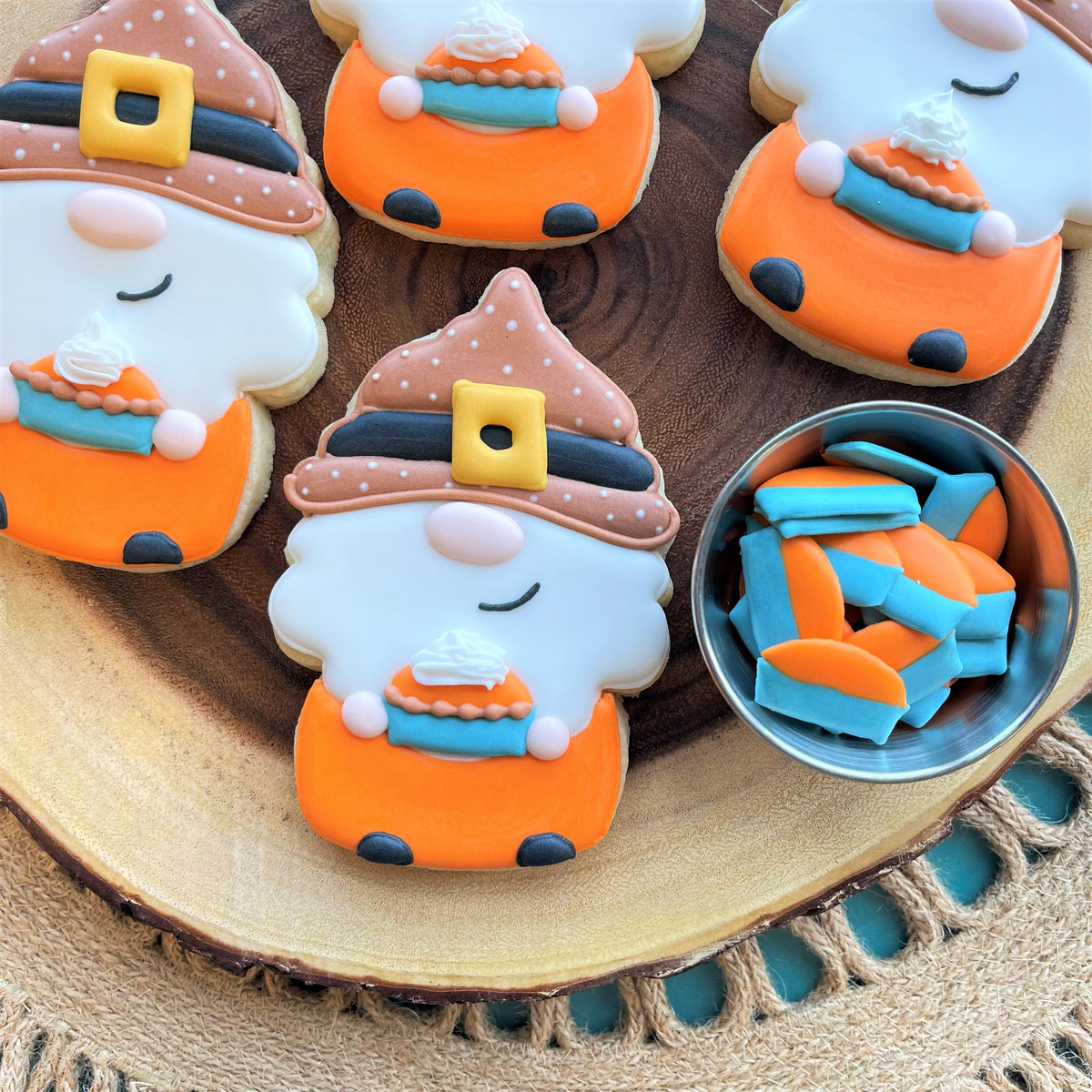 Orange and white halloween gnome-shaped sugar cookies with brown polka-dotted hats made using uncle sam gnome cookie cutter