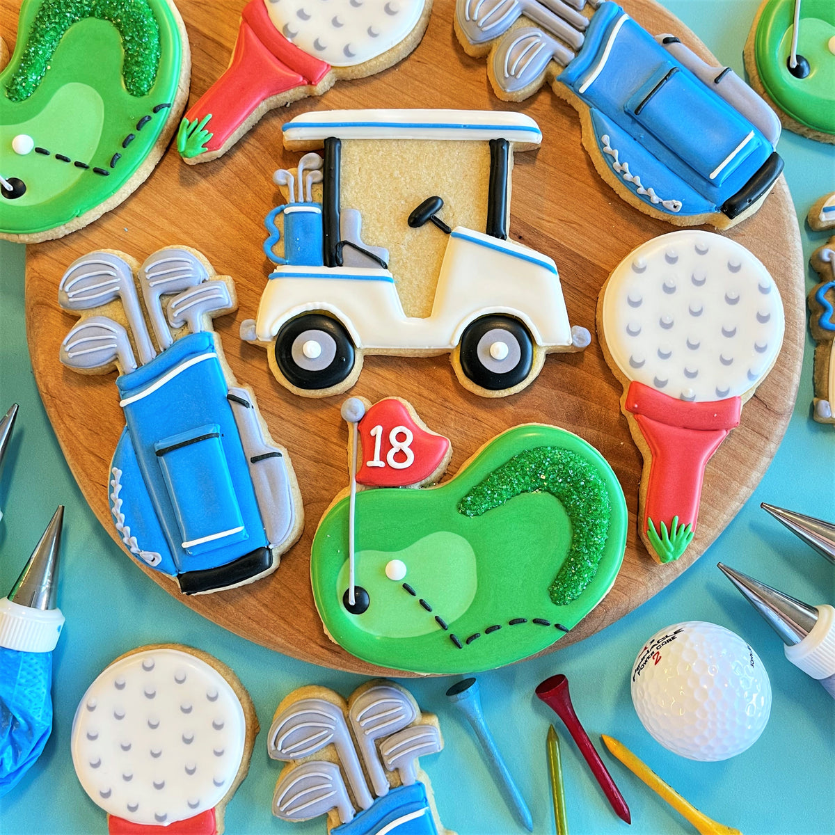 Golf cookie decorating class recording featuring a white and blue decorated golf cart cookie with black wheels and blue bag