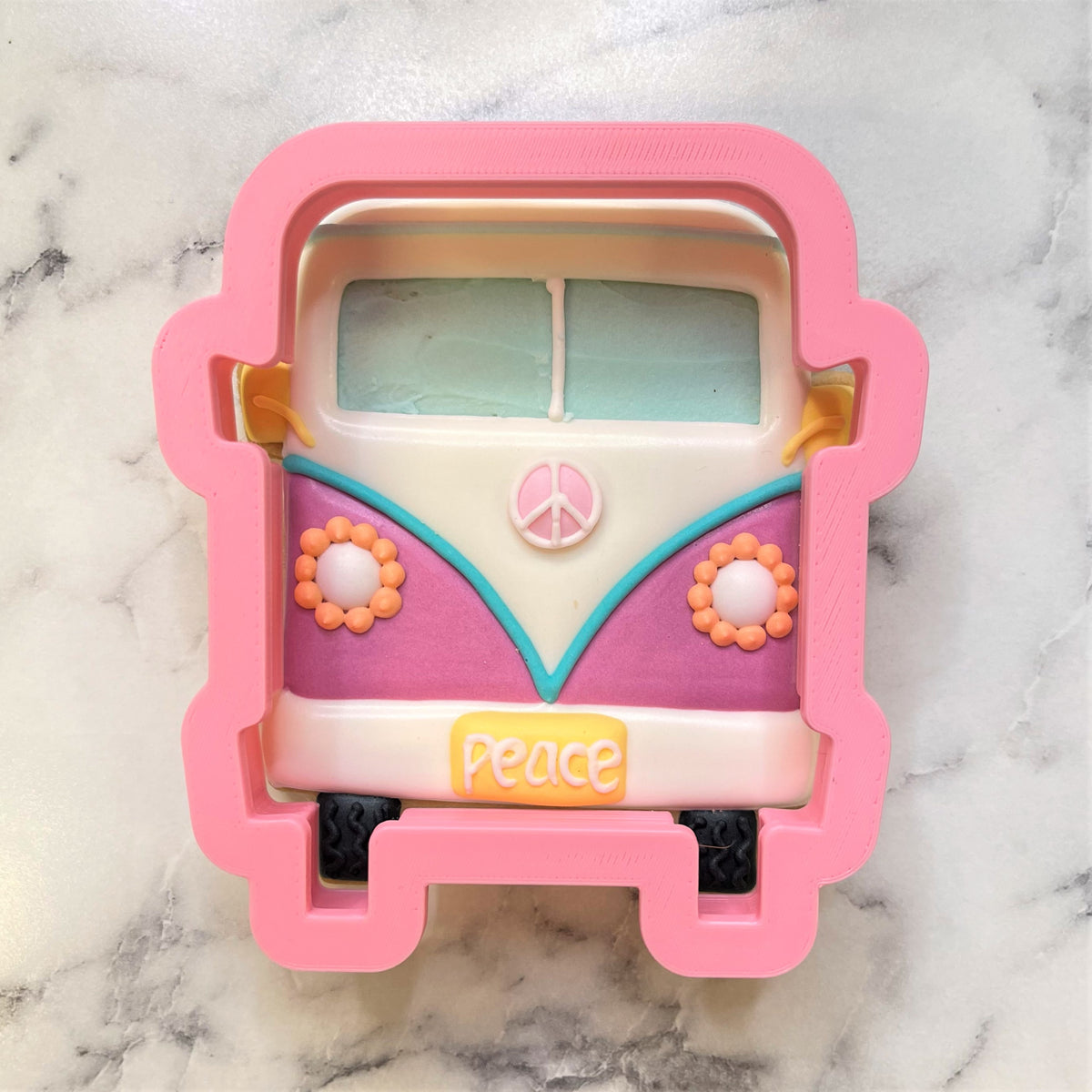 Pink silicone groovy bus cookie cutter shaped like a vintage volkswagen van with pastel accents and flower details