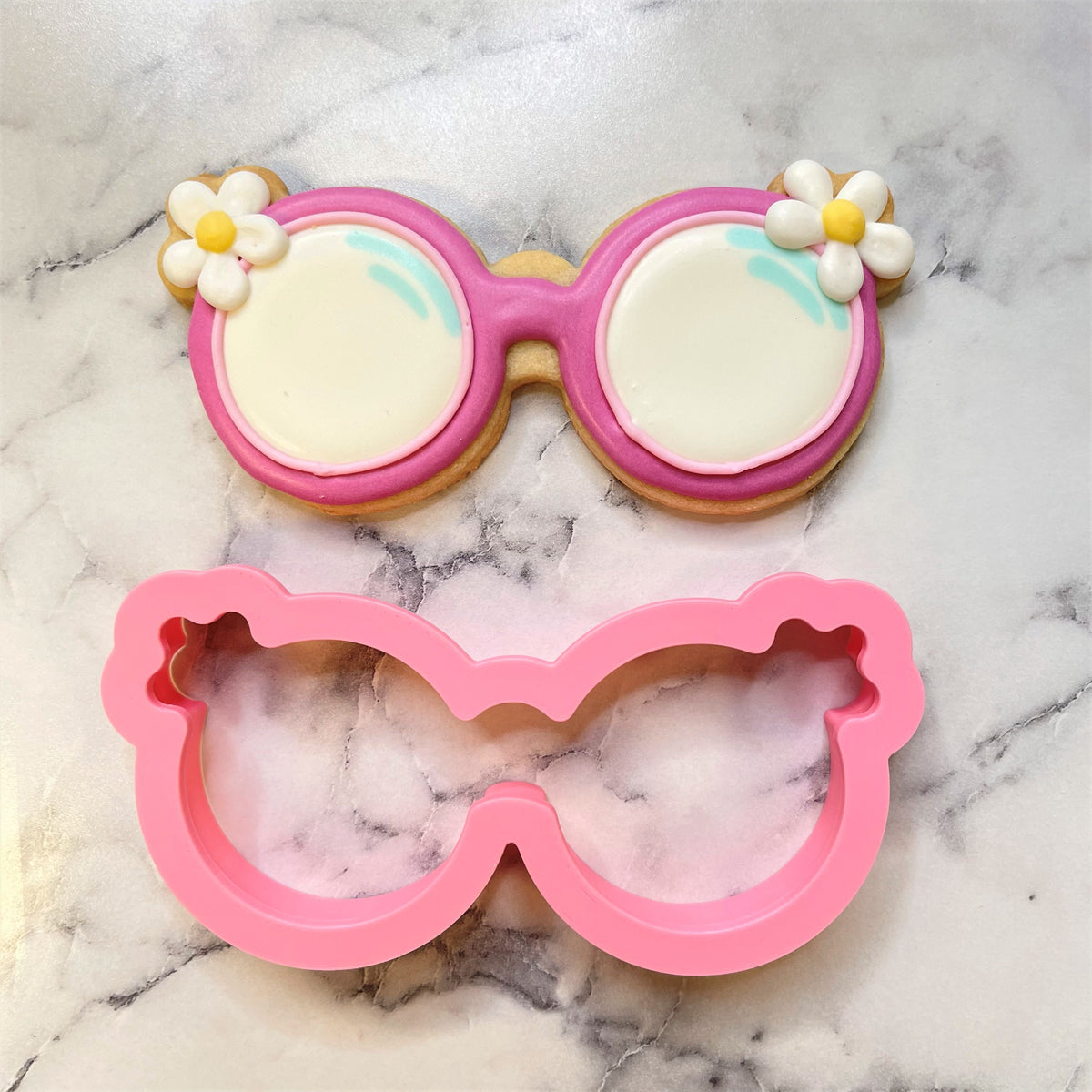 Pink silicone groovy sunglasses cookie cutter with matching decorated sugar cookie for fun baking designs