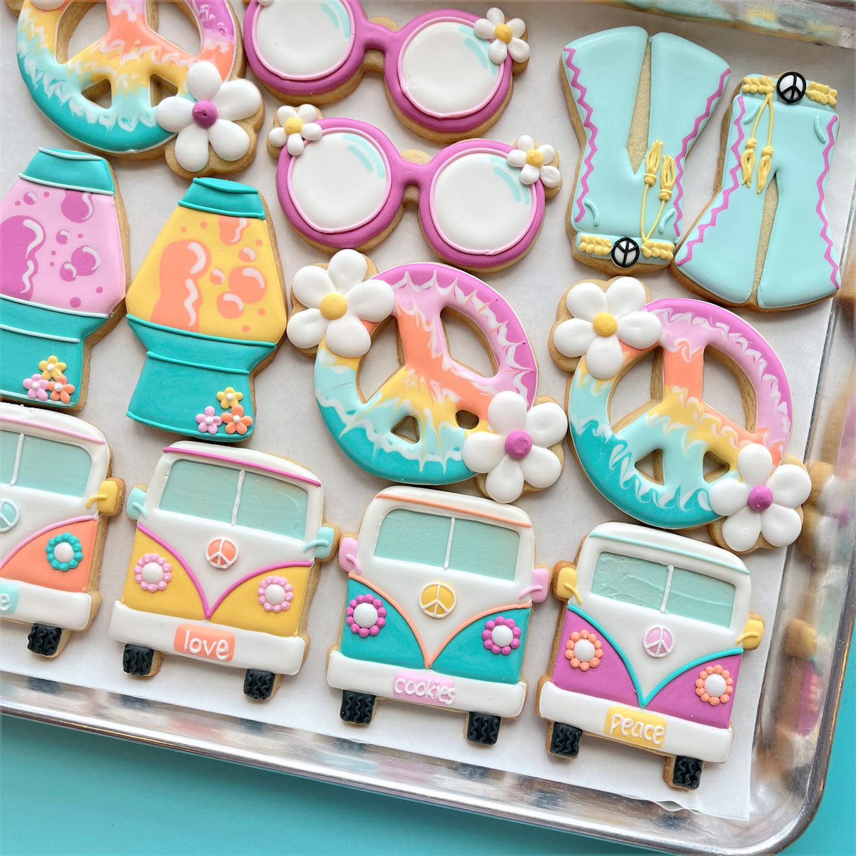 Pastel-colored sugar cookies shaped with groovy sunglasses cookie cutter featuring vintage vans and peace signs designs