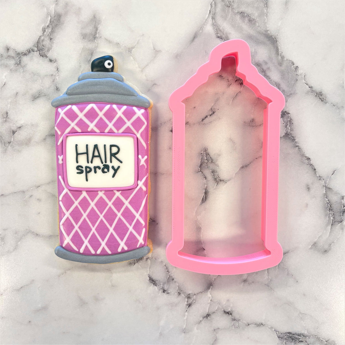 Pink and gray hair spray cookie shaped like a can with white label reading hair spray for use with hair spray cookie cutter