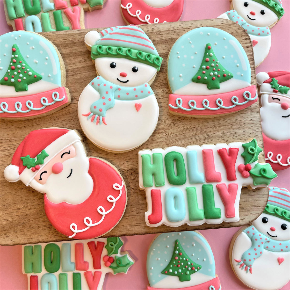 A festive holly jolly cookie with red and green icing made using a snow globe dome cookie cutter