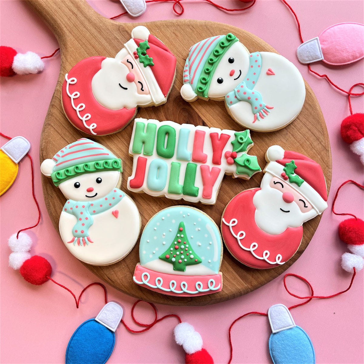 Christmas themed sugar cookies with santa and snowman designs in colorful icing on a wooden board holly jolly bundle
