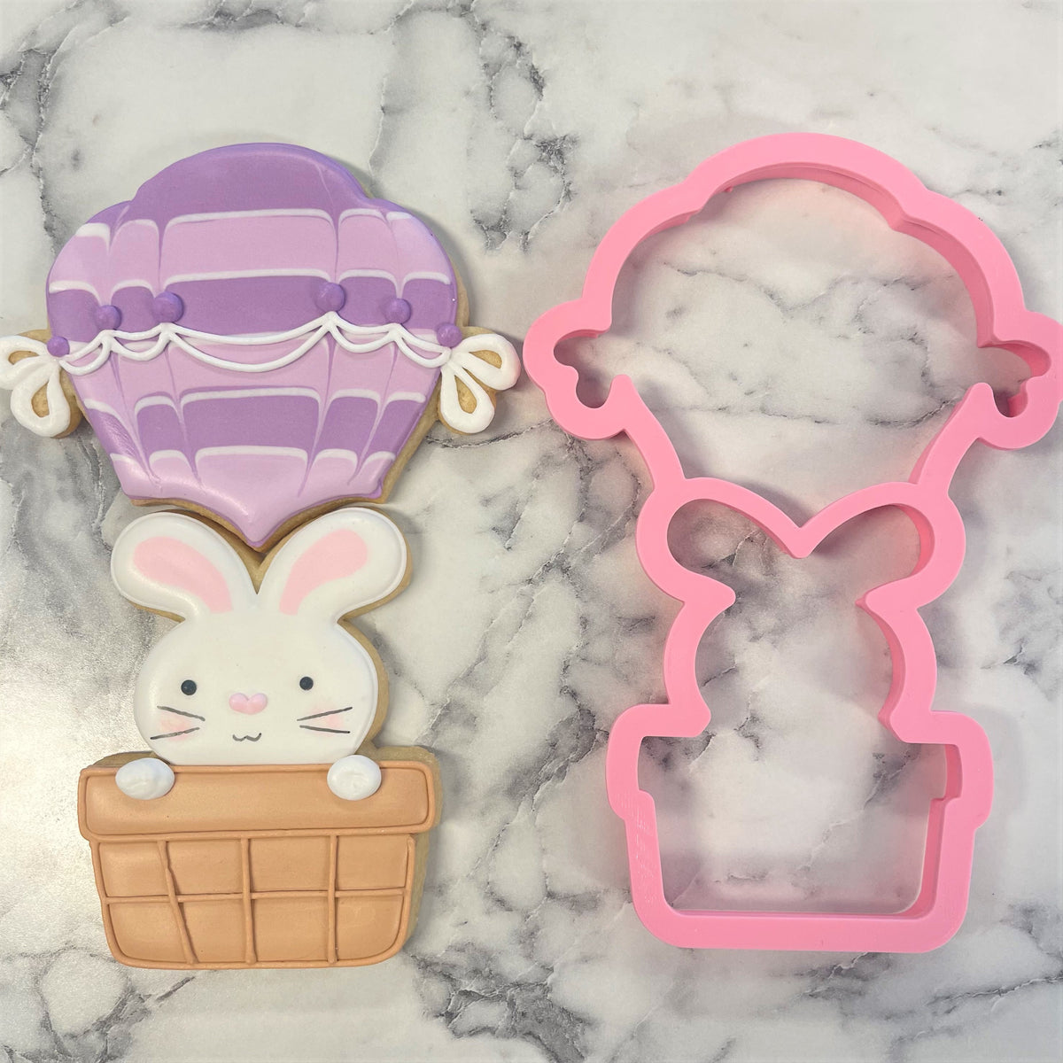 Pink hot air balloon cookie cutter with bunny design made of durable material for multi-use baking and crafting