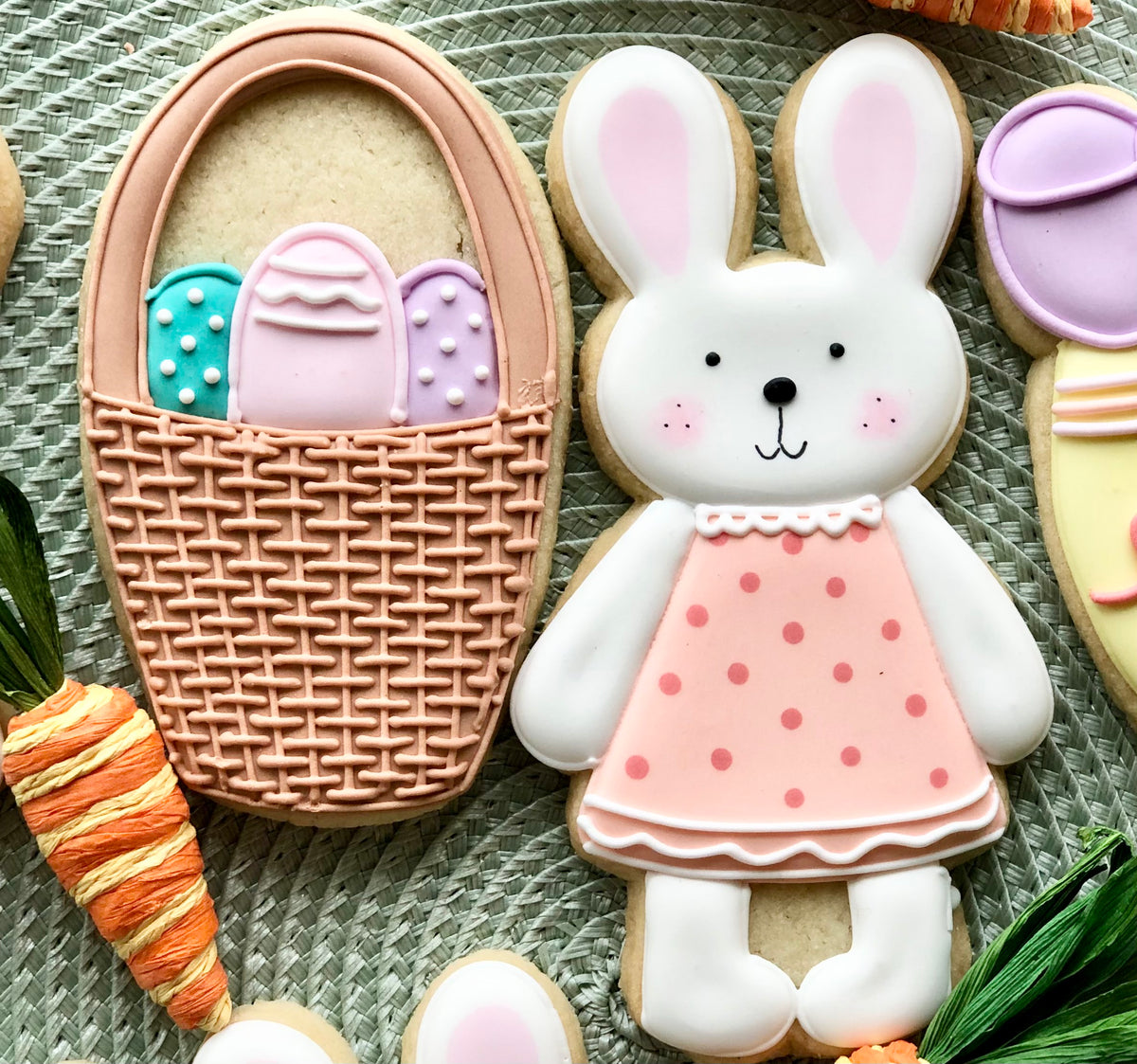 A pink polka-dot dress with white lace collar and ruffled hem worn by a sugar cookie bunny in easter cookie cutter set