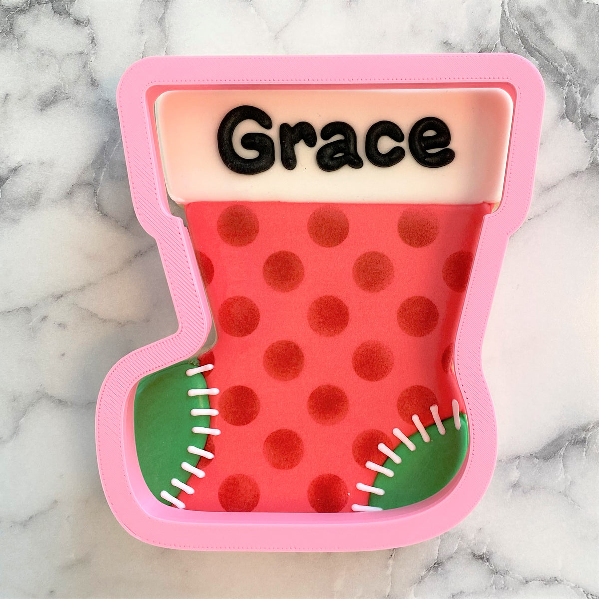 Pink silicone christmas stocking jumbo cookie cutter with red polka dots green toe and white stitching details