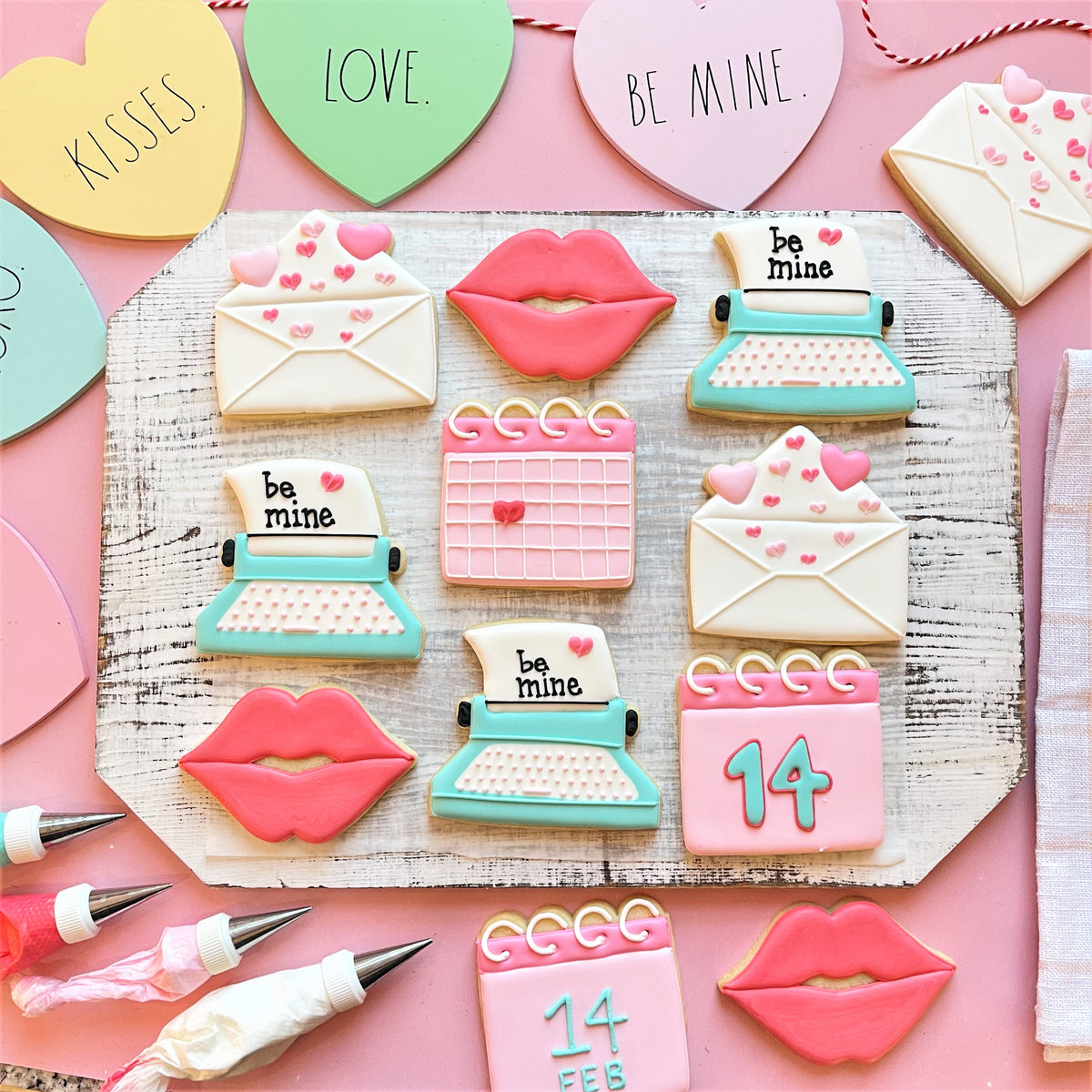 Envelope with hearts cookie cutter creates pink and teal sugar cookies shaped like lips, envelopes, typewriters, and hearts