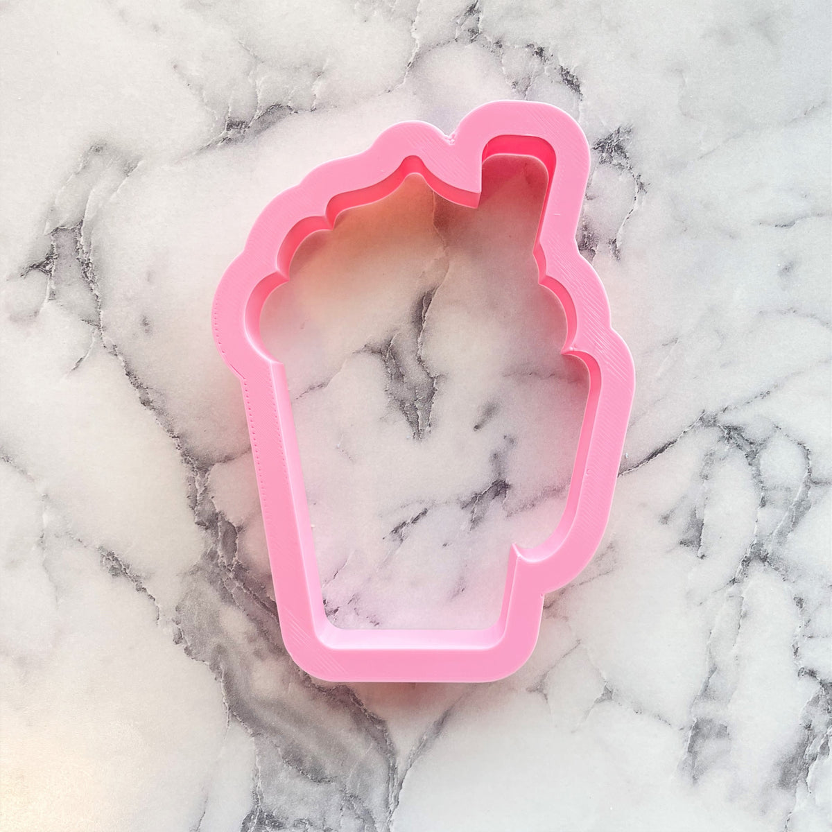 Latte cup with whipped cream pink plastic cupcake-shaped cookie cutter for baking and decorating treats