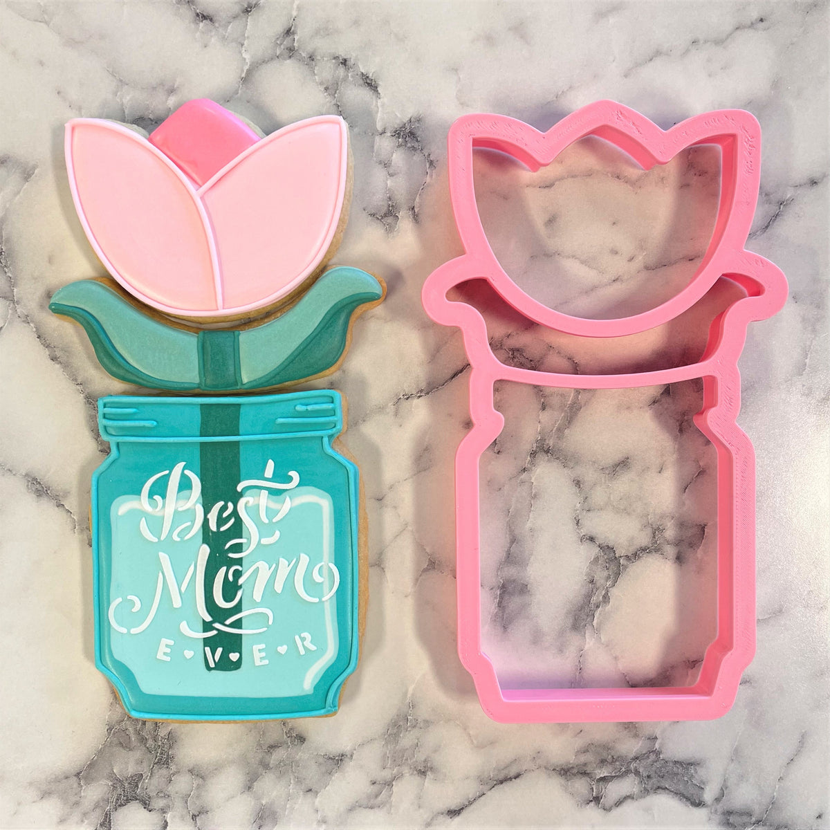 Pink tulip-shaped cookie cutter and matching decorated cookie from the mason jar with flower 3-in-1 multi-cookie cutter set