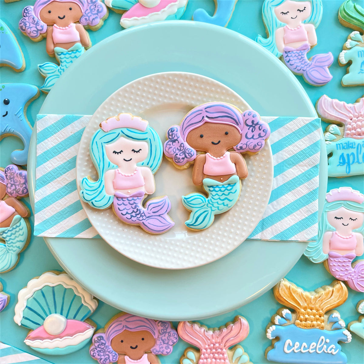 Pastel-colored mermaid-themed sugar cookies with intricate icing in soft pink blue and purple made with mermaid with tiara flour box club cutter