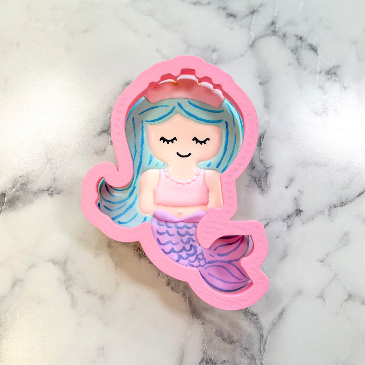 Pink silicone mermaid cookie cutter with blue and purple details for mermaid with tiara flour box club