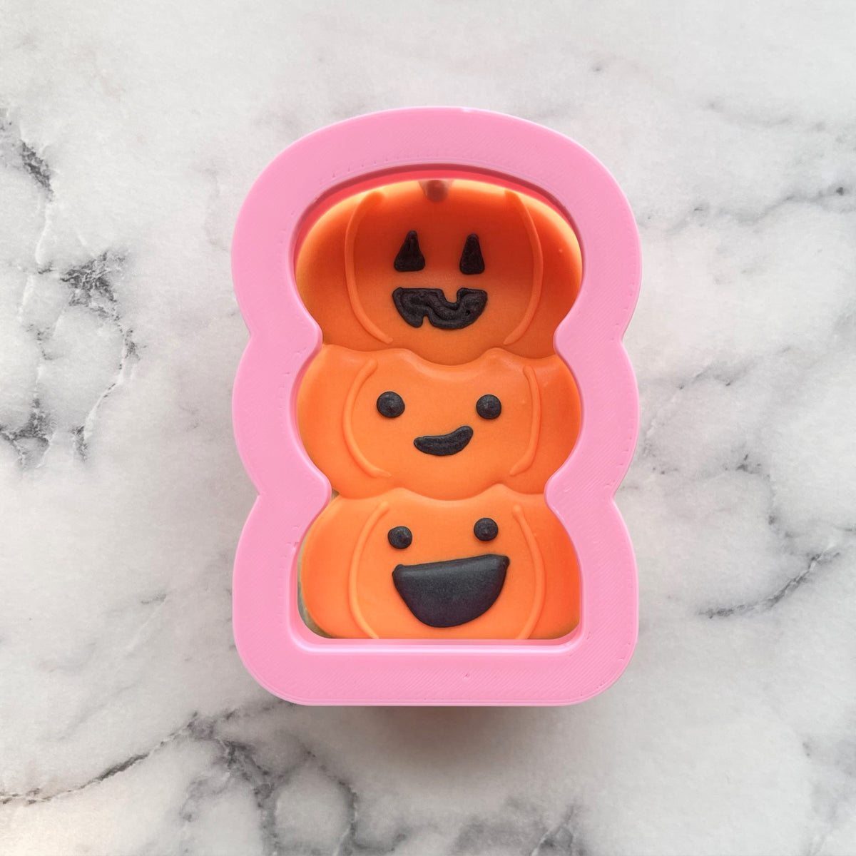 Mini boo cookie flip cutter pink silicone mold with three stacked orange pumpkins and black facial details