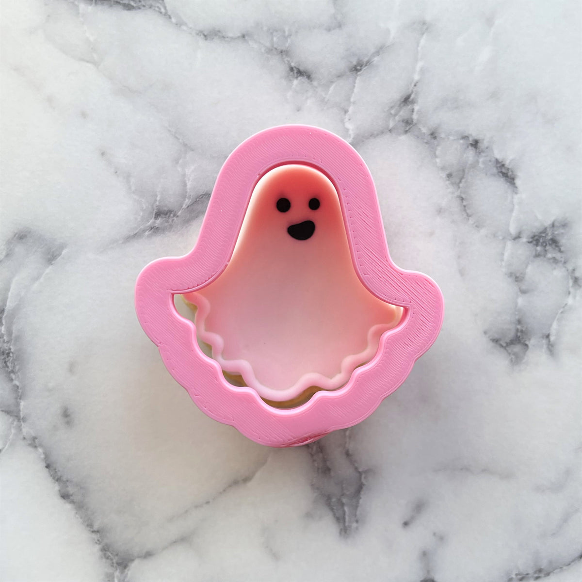 Pink mini classic ghost cookie cutter with black eyes and smiling mouth for baking and decorating cookies