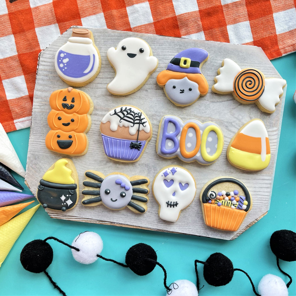A collection of halloween-themed mini boo cookie flip cutter sugar cookies decorated with vibrant spooky icing designs