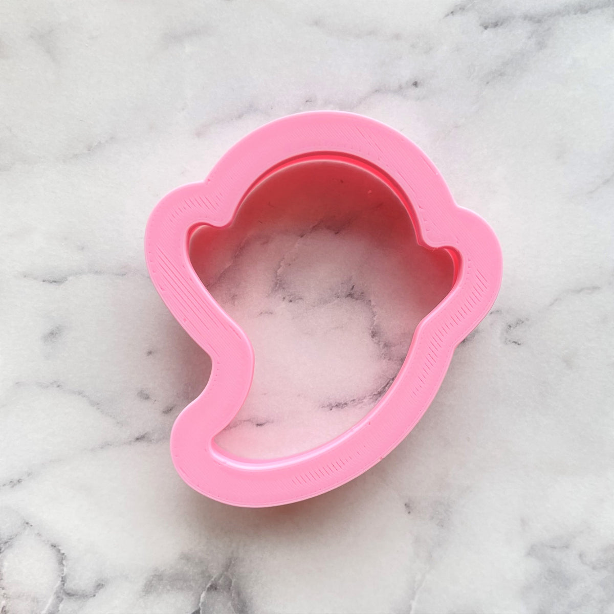 Pink silicone mini ghost cookie flip cutter mold shaped like a cartoon character head for baking use