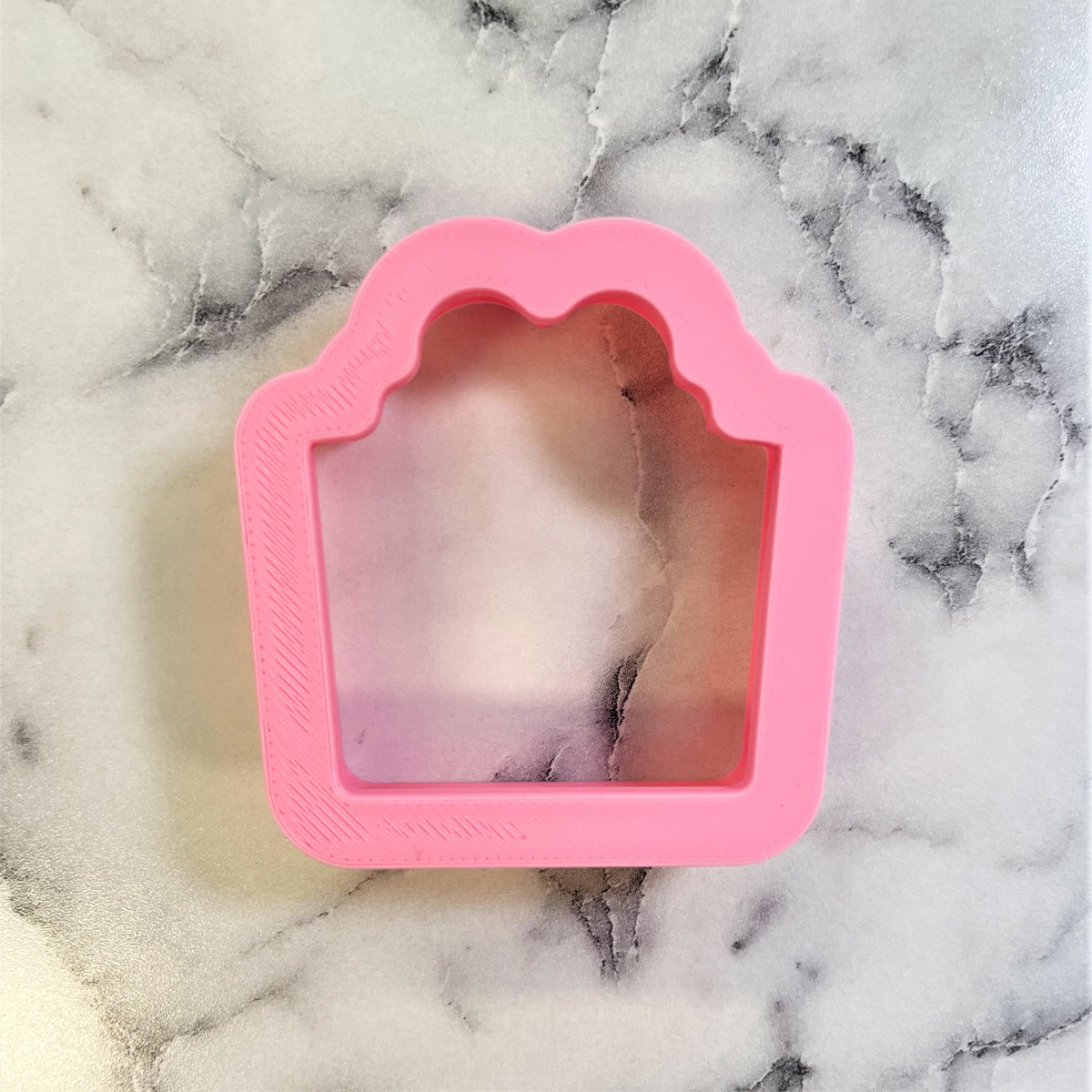 Pink silicone mini classic present cookie cutter with scalloped top edge and textured interior for baking shapes