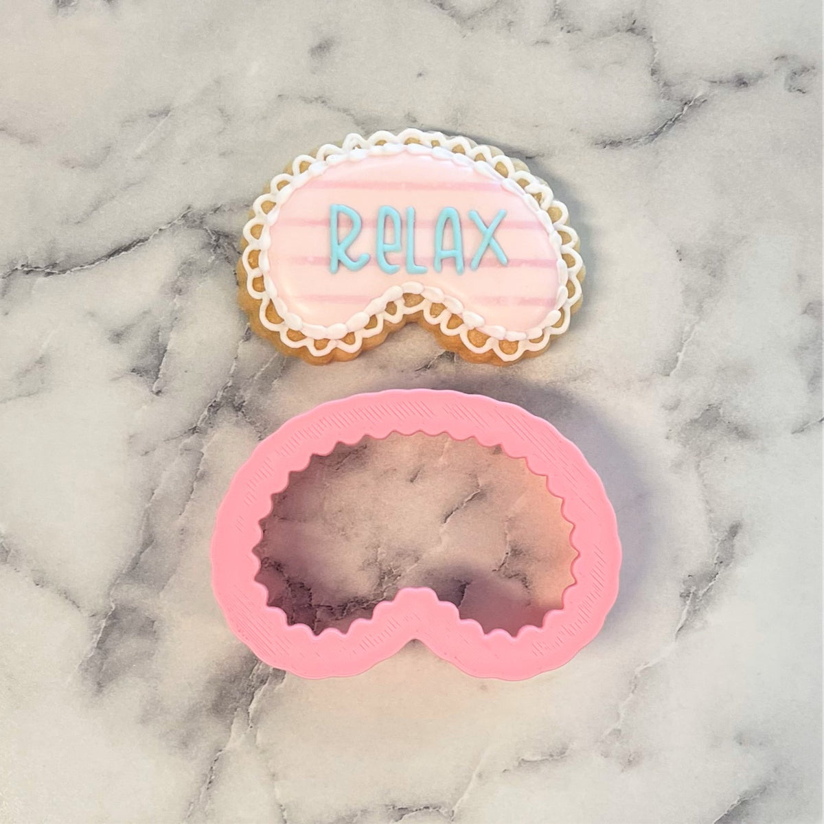 Mini face mask cookie cutter in pink silicone with scalloped edge for baking and crafting